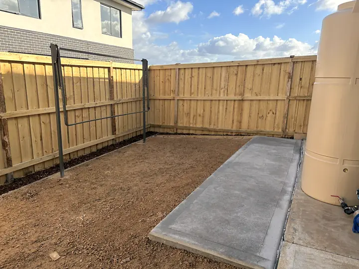 New concrete side path beside a fresh timber paling fence